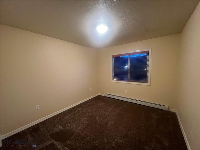 spare room featuring baseboard heating and a textured ceiling