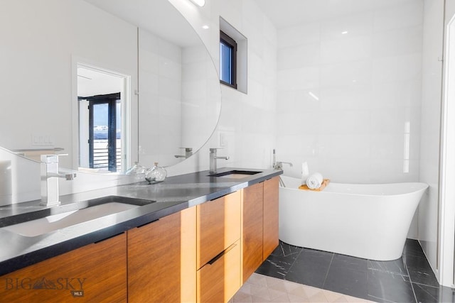 bathroom with tile patterned flooring, a tub to relax in, and vanity