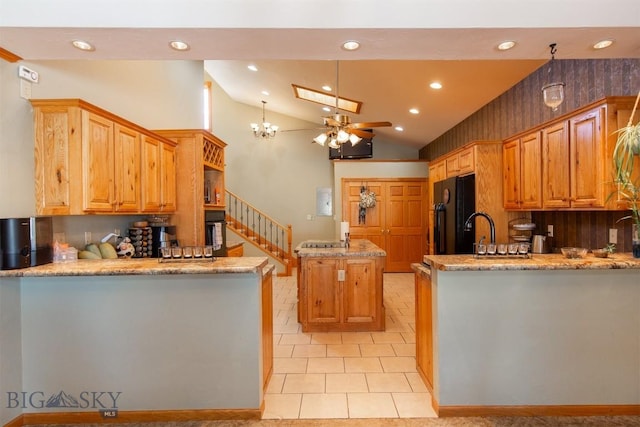 kitchen featuring recessed lighting, light stone counters, vaulted ceiling, black appliances, and a peninsula
