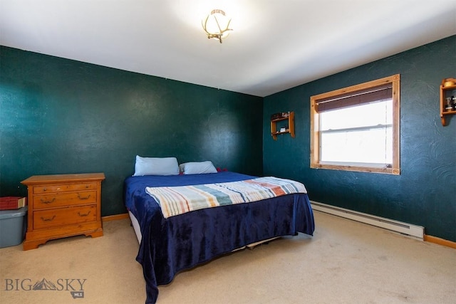 bedroom with a baseboard heating unit, carpet flooring, and baseboards