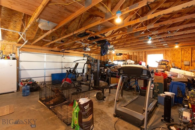 garage featuring freestanding refrigerator and a garage door opener