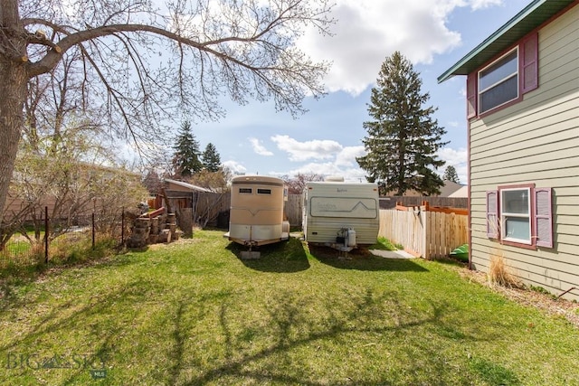 view of yard featuring a storage unit, fence, and an outbuilding