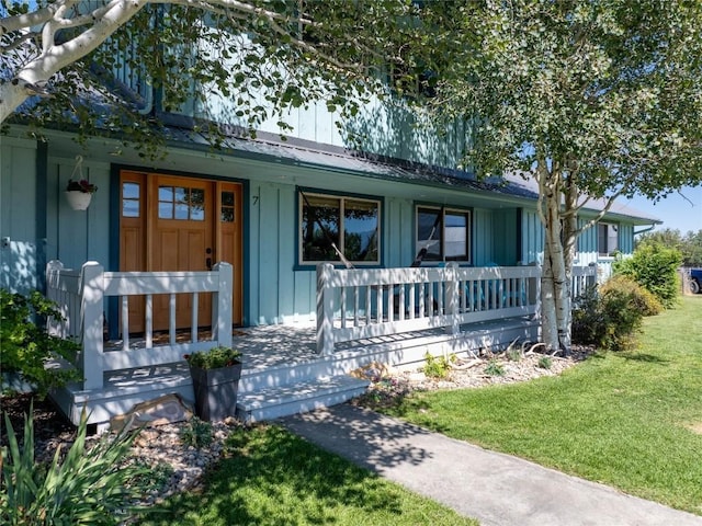 7 Hardy, Ennis, MT 59729 - view of front of home featuring covered porch, board and batten siding, a front yard, and metal roof