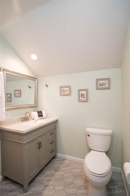 7 Hardy, Ennis, MT 59729 - half bathroom with vaulted ceiling, toilet, vanity, and baseboards