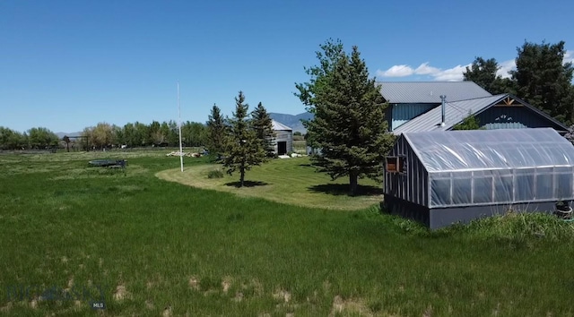 7 Hardy, Ennis, MT 59729 - view of grassy yard featuring a greenhouse and an outbuilding