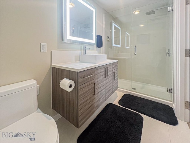 bathroom featuring toilet, tile patterned floors, a shower with door, and vanity