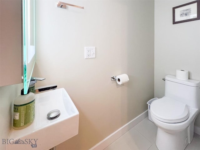 bathroom featuring toilet, tile patterned floors, and sink