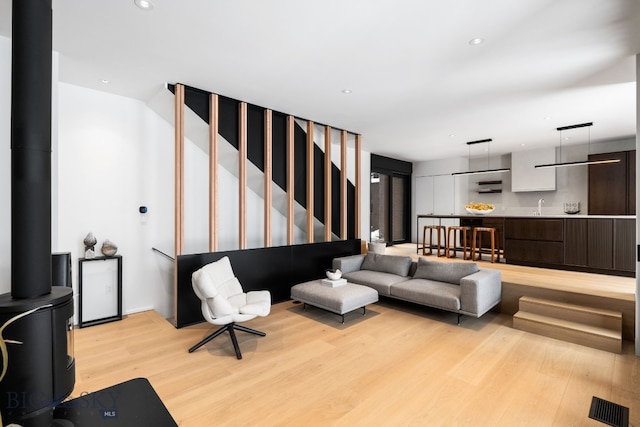 living room with sink and light hardwood / wood-style flooring