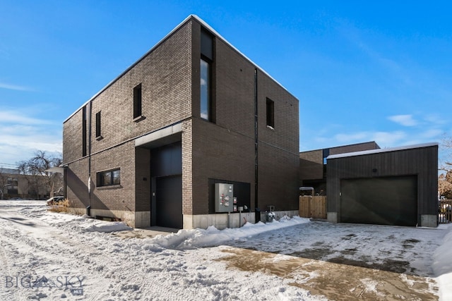 view of snow covered exterior featuring a garage