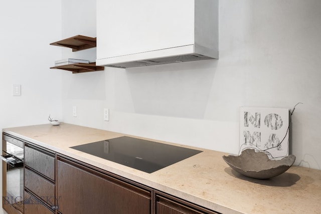 kitchen with black electric stovetop and dark brown cabinetry