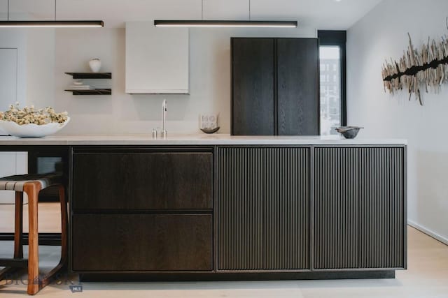 kitchen with a breakfast bar, light hardwood / wood-style flooring, and sink