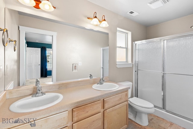 bathroom featuring tile patterned floors, a shower with door, toilet, and vanity