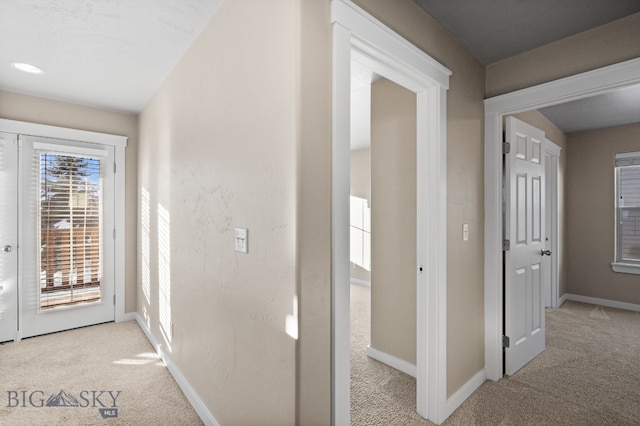 hallway featuring light colored carpet