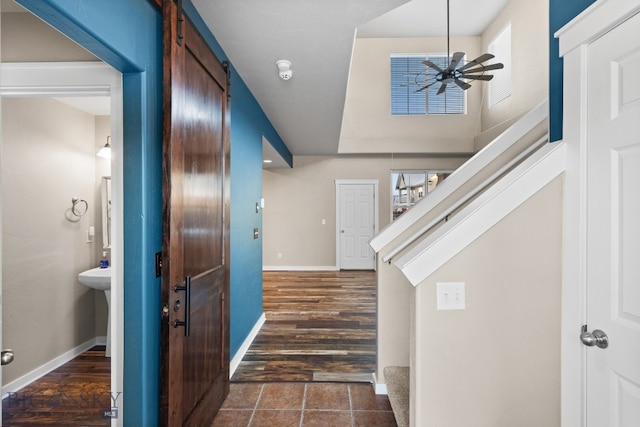 foyer entrance featuring ceiling fan, a barn door, and a healthy amount of sunlight