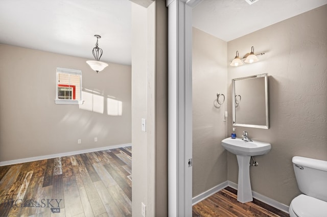 bathroom featuring toilet, sink, and hardwood / wood-style flooring