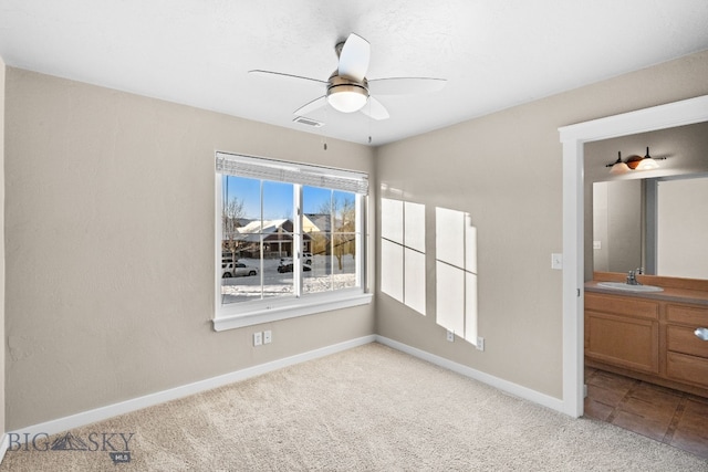 spare room featuring ceiling fan, light colored carpet, and sink