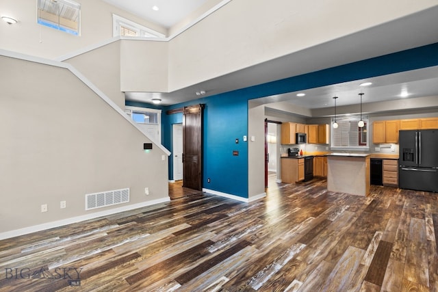 unfurnished living room featuring dark hardwood / wood-style flooring and a high ceiling