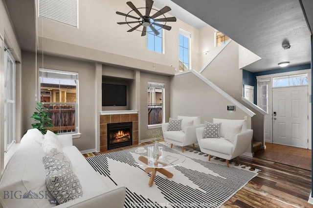 3911 Bosal St, Bozeman, MT 59718 - living room featuring a ceiling fan, wood finished floors, stairway, a fireplace, and a high ceiling