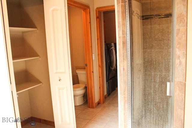 bathroom featuring a stall shower, tile patterned flooring, and toilet