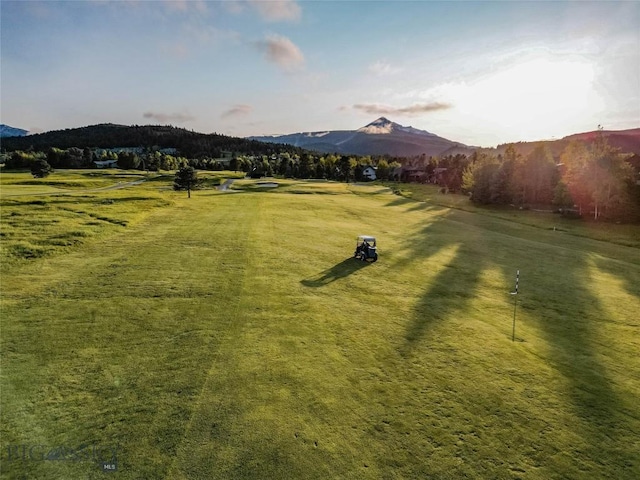 surrounding community with a rural view, a mountain view, and a lawn