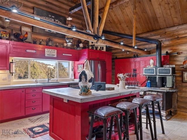 107 Dry Creek Trl, Ennis, MT 59729 - kitchen featuring a sink, wood ceiling with exposed beams, a kitchen island, freestanding refrigerator, and a kitchen bar