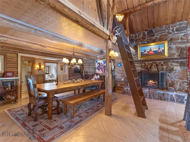 107 Dry Creek Trl, Ennis, MT 59729 - dining space featuring a chandelier, a stone fireplace, light wood finished floors, log walls, and wood ceiling with exposed beams