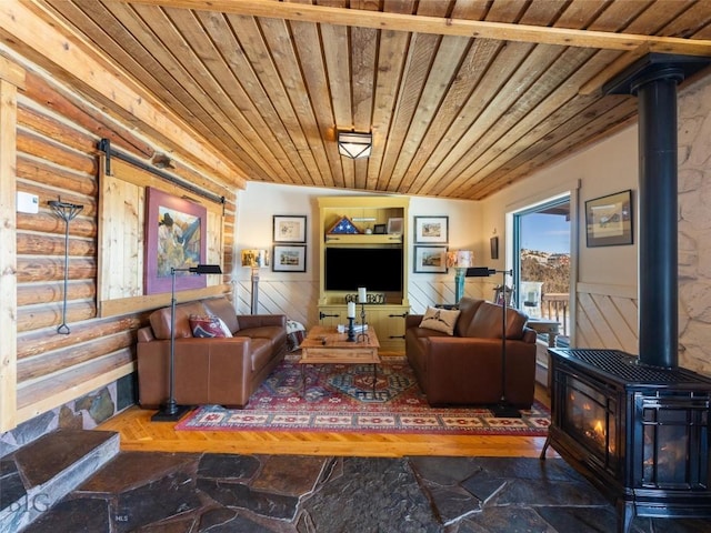 107 Dry Creek Trl, Ennis, MT 59729 - living room with a wood stove, wood ceiling, stone finish flooring, a wainscoted wall, and rustic walls
