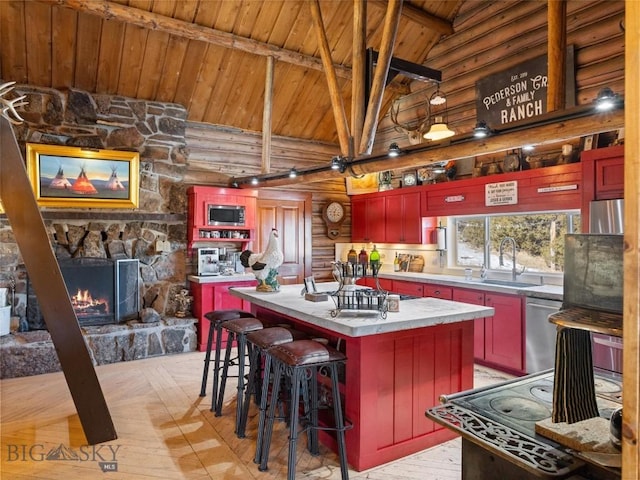 107 Dry Creek Trl, Ennis, MT 59729 - kitchen featuring wood ceiling with exposed beams, stainless steel appliances, a sink, log walls, and high vaulted ceiling