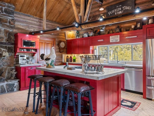 107 Dry Creek Trl, Ennis, MT 59729 - kitchen featuring stainless steel appliances, rustic walls, a sink, wooden ceiling, and light wood-style floors