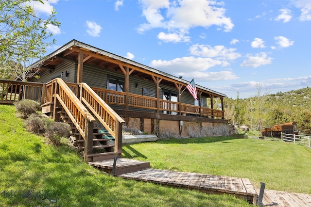 107 Dry Creek Trl, Ennis, MT 59729 - back of property featuring a lawn, a wooden deck, and stairs