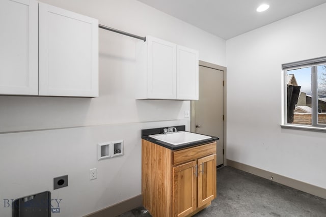 clothes washing area featuring cabinets, hookup for a washing machine, electric dryer hookup, and sink