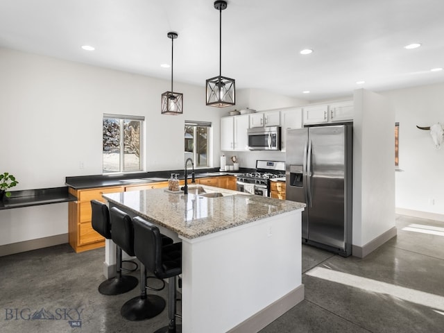 kitchen with a kitchen island, pendant lighting, sink, white cabinetry, and stainless steel appliances