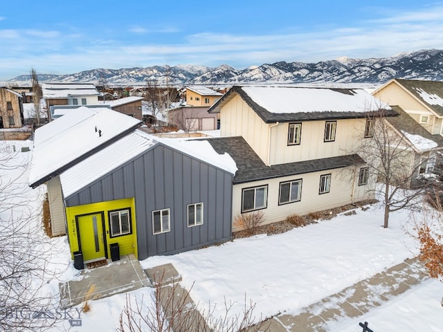 snow covered back of property with a mountain view