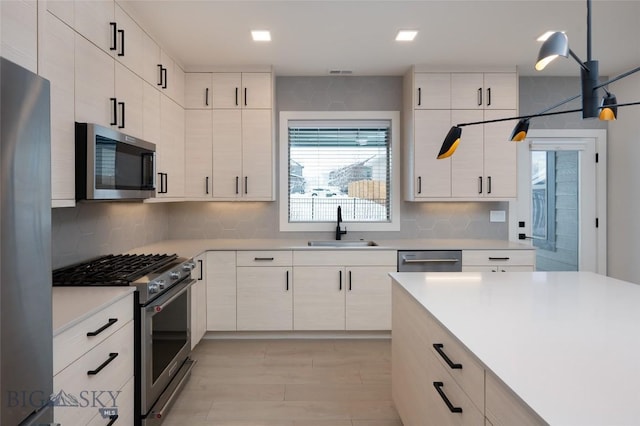 kitchen featuring tasteful backsplash, sink, decorative light fixtures, and stainless steel appliances