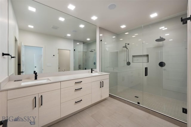 bathroom featuring vanity, a shower with shower door, and tile patterned floors