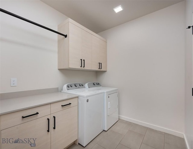 washroom with independent washer and dryer, light tile patterned floors, and cabinets