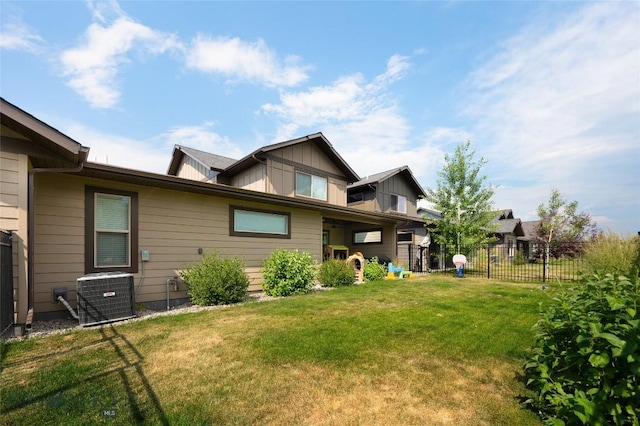 rear view of house with a yard and central AC