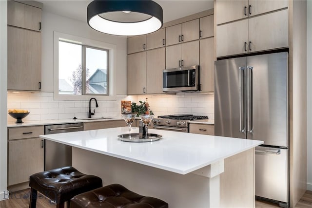 kitchen featuring tasteful backsplash, high quality appliances, a kitchen breakfast bar, and a center island