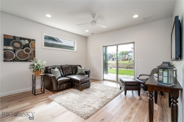 living room with light hardwood / wood-style floors and ceiling fan