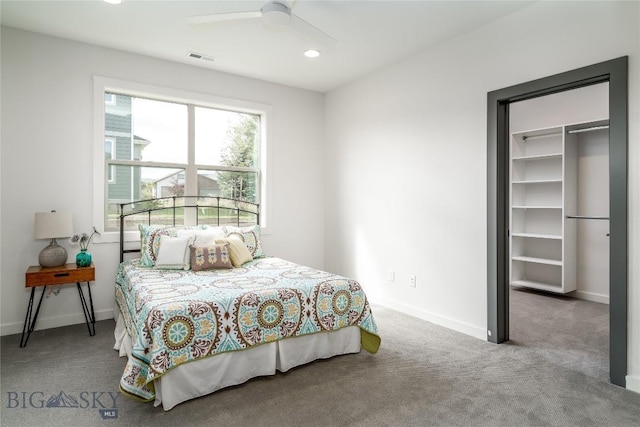 carpeted bedroom featuring ceiling fan, a spacious closet, and a closet