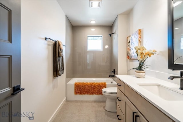 full bathroom with tile patterned flooring, tiled shower / bath, vanity, and toilet