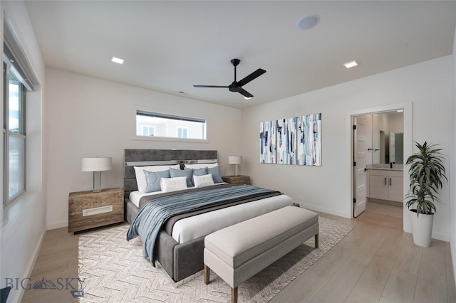 bedroom featuring ceiling fan, ensuite bathroom, light hardwood / wood-style floors, and multiple windows