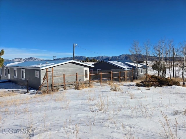 snow covered house featuring a mountain view