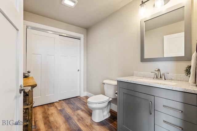 bathroom with wood-type flooring, toilet, and vanity