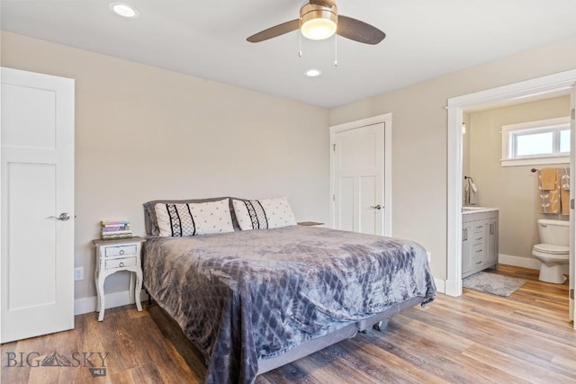 bedroom with ceiling fan, ensuite bathroom, and wood-type flooring