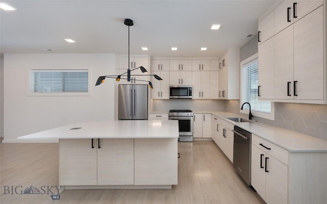 kitchen with a center island, appliances with stainless steel finishes, decorative backsplash, white cabinets, and decorative light fixtures