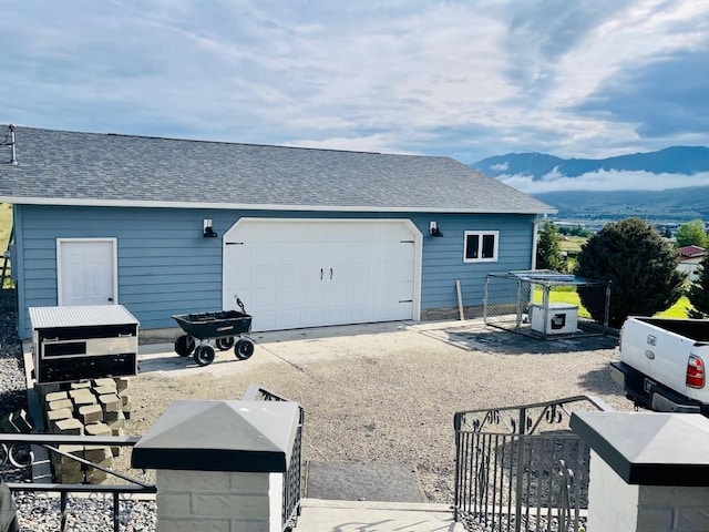 rear view of house featuring an outbuilding, a mountain view, and a garage