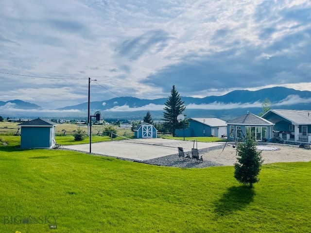 surrounding community featuring a storage unit, a yard, and a mountain view