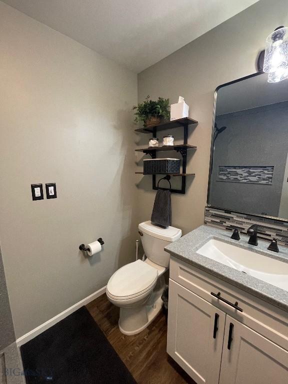 bathroom featuring wood-type flooring, vanity, and toilet