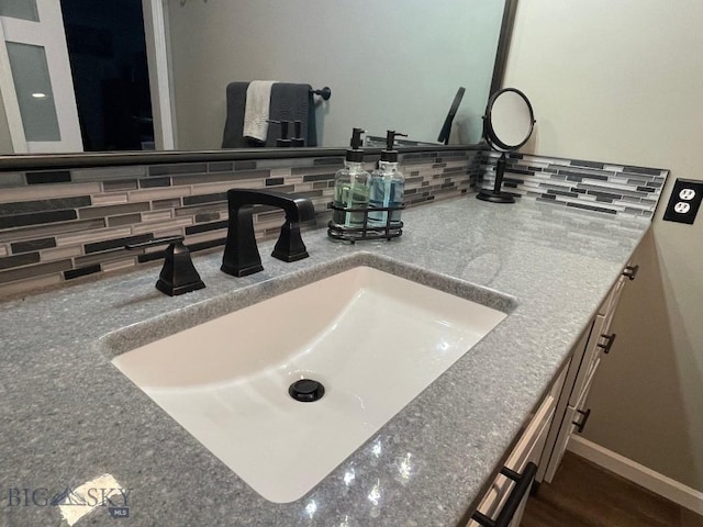 bathroom featuring vanity and backsplash